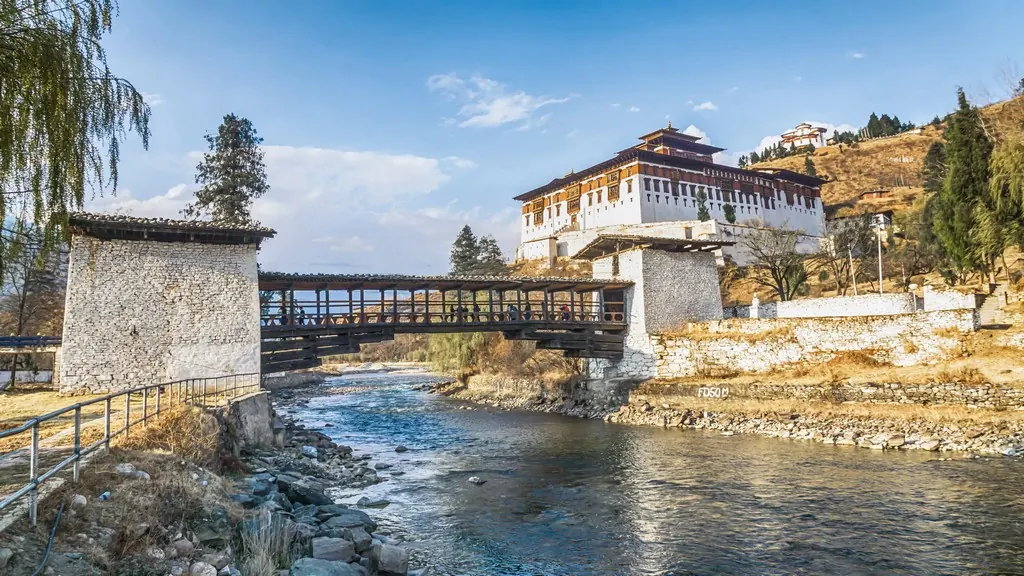 A covered bridge below a dzong in Paro